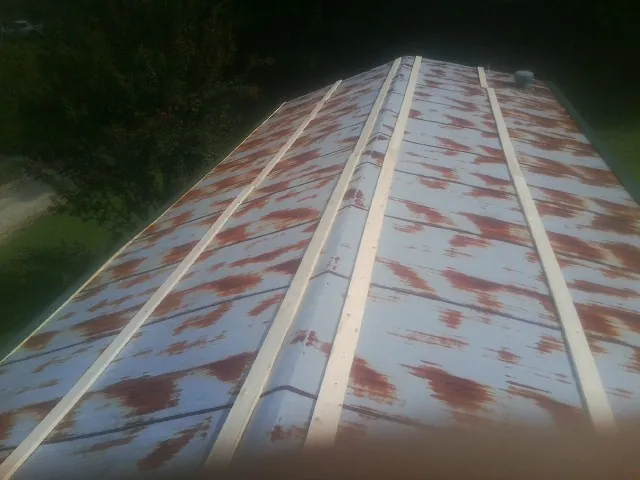 Rusted metal roof panels with new wood purlins before replacement — Storm Damage Roof Repair in Bluffton by Roofing Brothers